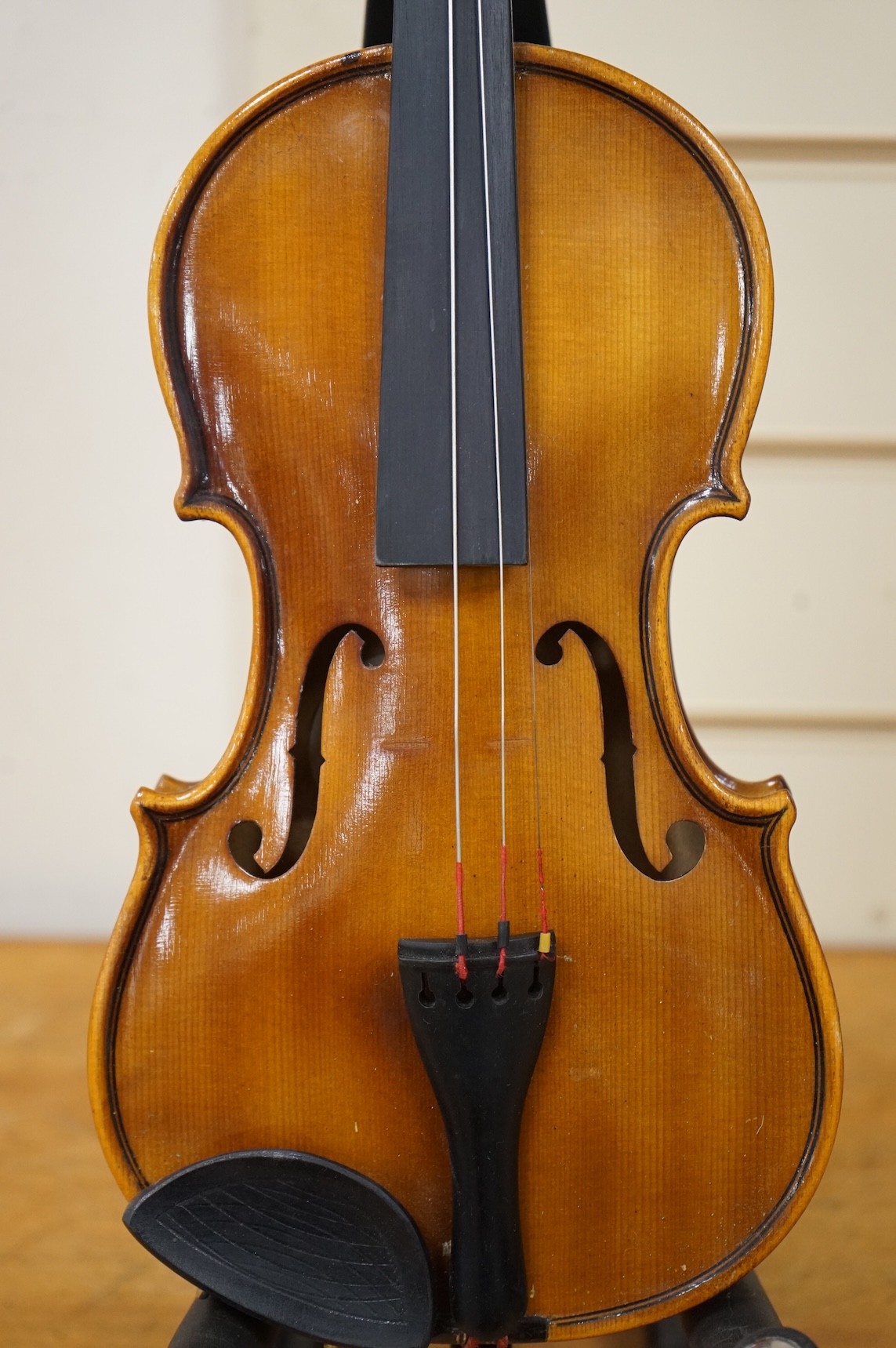 Five cased 20th century violins, including; a German violin, two Czech violins, a three-quarter size violin with a label for Bienfait, and a Romanian quarter size violin, all in cases or the remains of cases.